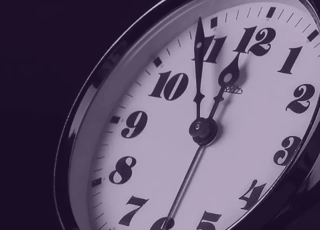 Clock in purple hue ticking Five before Twelve